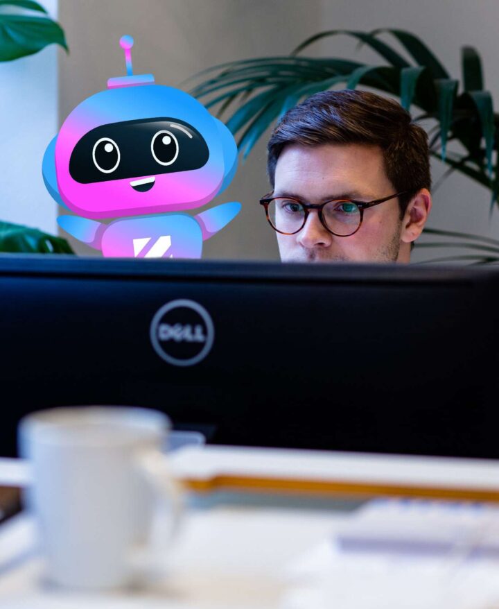 Anställd man på Zimply och AI-assistent maskot arbetar tillsammans vid en datorskärm